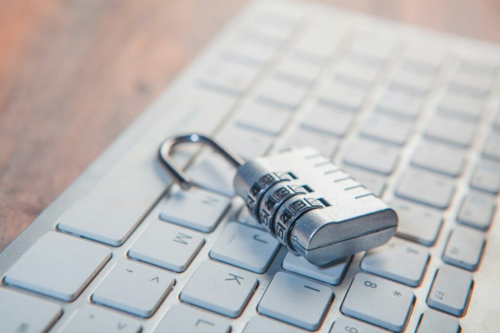 Vorhängeschloss neben einem Laptop als Symbol für IT-Sicherheit im Büro
